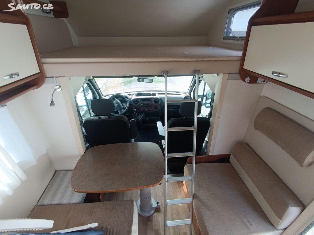 Interiér obytného vozu - pohled na spací prostor s lůžkem